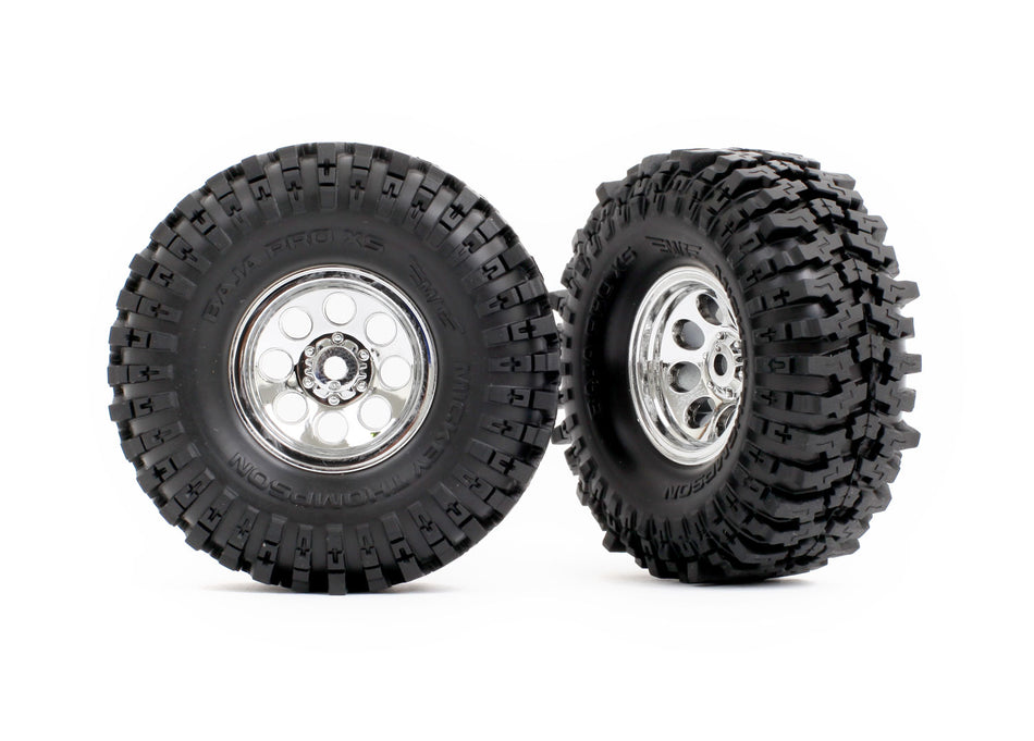 Two black off-road tires with silver rims on a white background